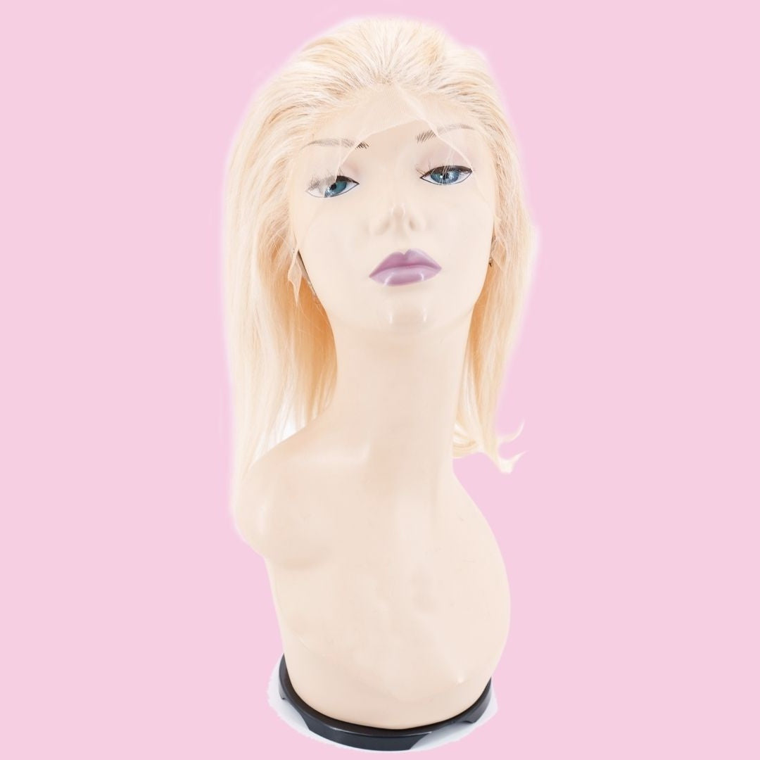 Blonde straight bob human hair wig on a mannequin head against a pink background with the uncut lace front draped over the face