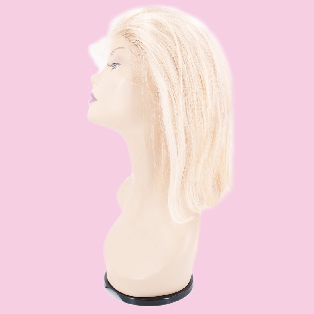 Blonde straight bob human hair wig on a mannequin head from the side against a pink background showing the blunt cut line