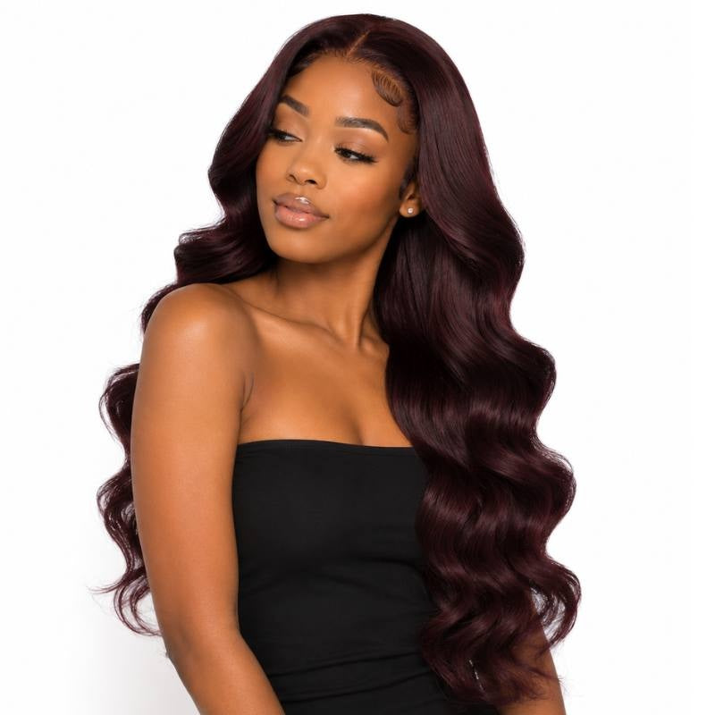 Model wearing burgundy 99J body wave sew-in hair extensions installed with a middle part and long waves on a white background