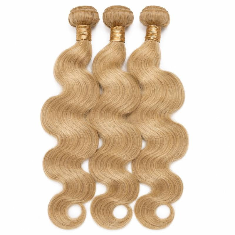 Three bundles of honey blonde 27 body wave sew-in hair extensions standing side by side with gold bands at the wefts on white