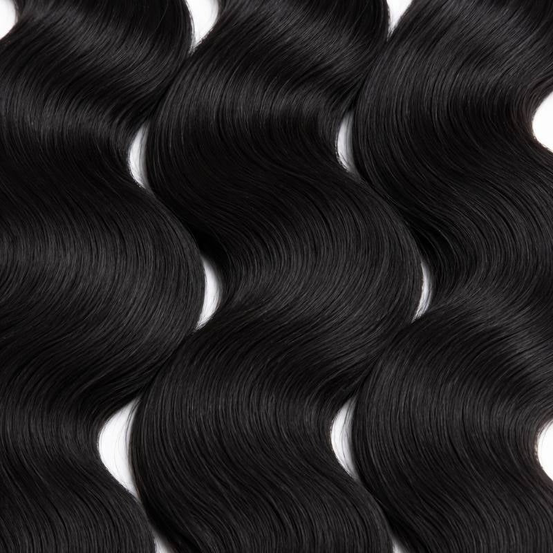 Macro crop of the wave pattern across three bundles of jet black 1 body wave sew-in hair extensions on a white surface