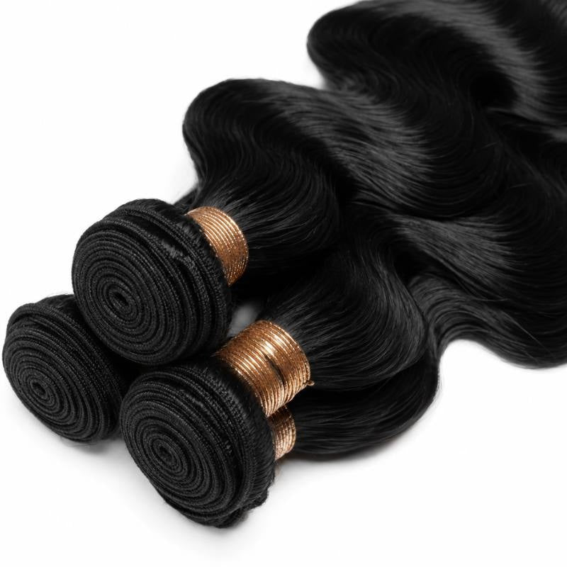 Close-up of the coiled wefts and gold bands on three bundles of jet black 1 body wave sew-in hair extensions laid on white