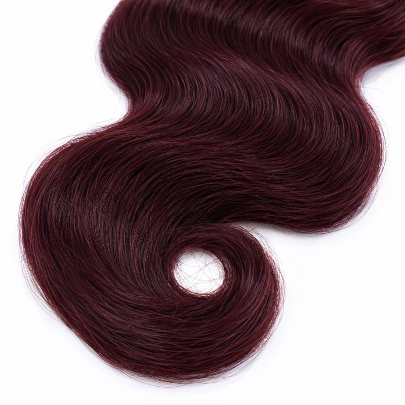 Close view of the curled end on a single bundle of burgundy 99J body wave sew-in hair extensions laid on a white surface