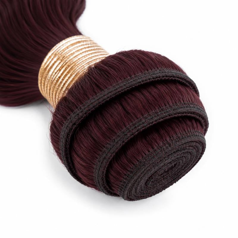 Close-up of the coiled weft and gold band on a single bundle of burgundy 99J body wave sew-in hair extensions showing the stitching