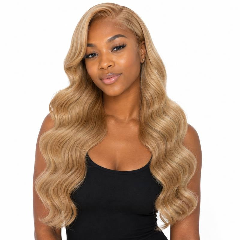 Model facing forward wearing honey blonde 27 body wave sew-in hair extensions with a middle part and long waves on white