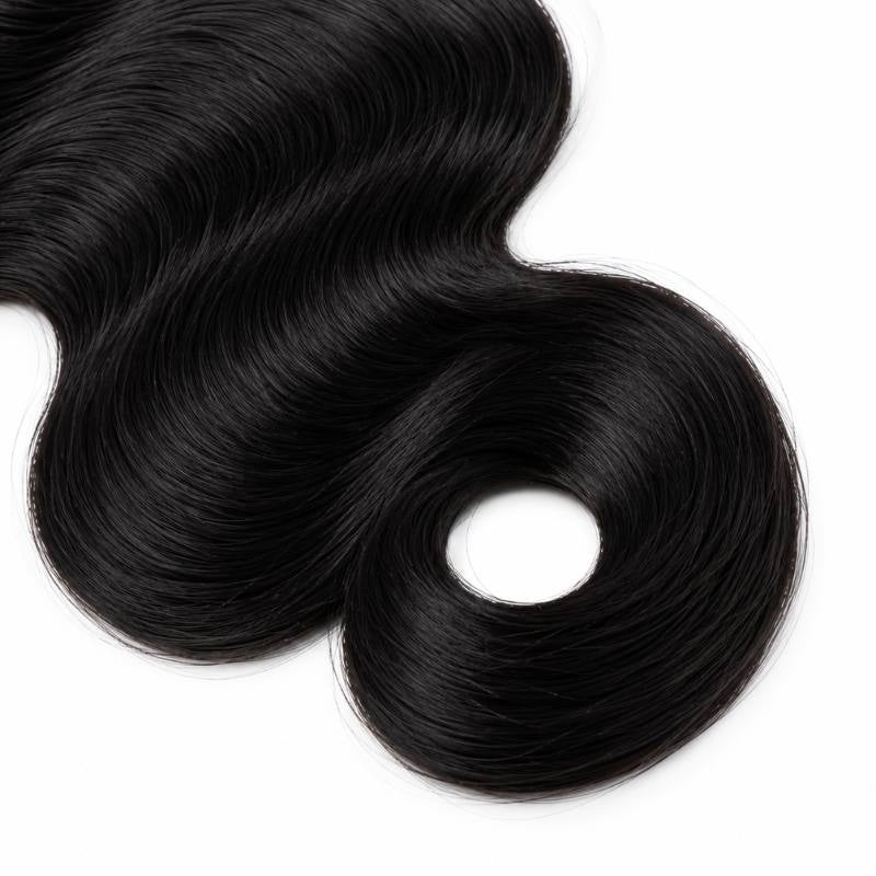 Macro view of the curled end on a single bundle of jet black 1 body wave sew-in hair extensions laid on a white surface