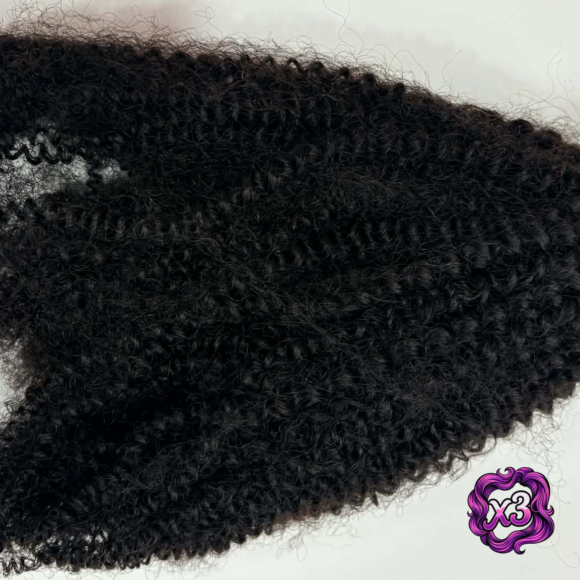 3 bundle deal — Close-up flat lay of 16 inch Brazilian afro kinky curly sew-in hair extensions bundle showing coil texture detail and volume