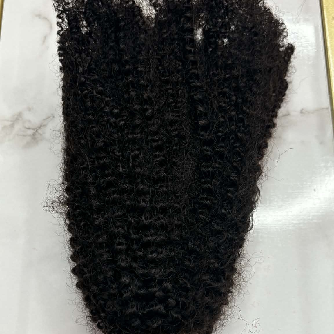 16 inch Brazilian afro kinky curly sew-in hair extensions bundle in gold frame showing tight coils spread across marble surface