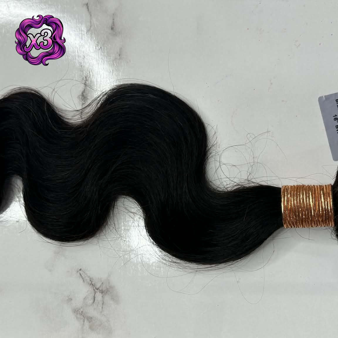 3 bundle deal — 16 inch Brazilian body wave sew-in hair extensions bundle flat lay on marble with product label showing loose S-wave pattern and weft