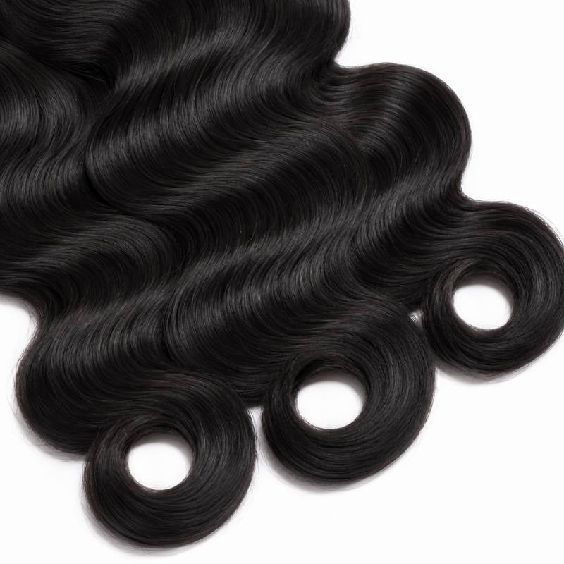 Close-up of the curled ends of three bundles of natural black body wave sew-in hair extensions forming ring shaped tips on white