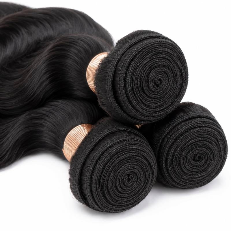 Close-up of the spiral coiled weft ends on three bundles of natural black body wave sew-in hair extensions with tan thread wraps