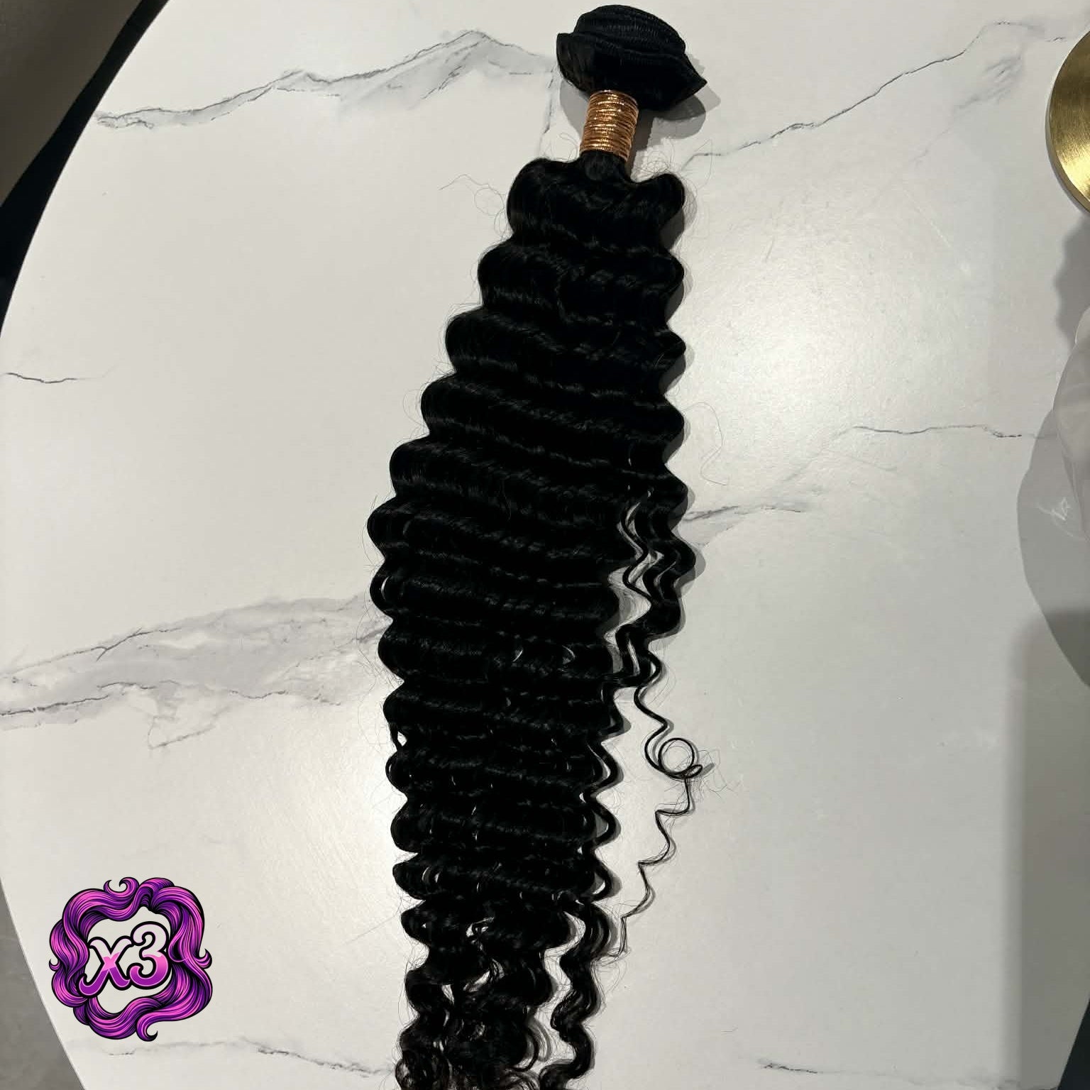 3 bundle deal — 16 inch Brazilian deep wave sew-in hair extensions bundle on marble table showing full length from rubber-banded weft to curl tips