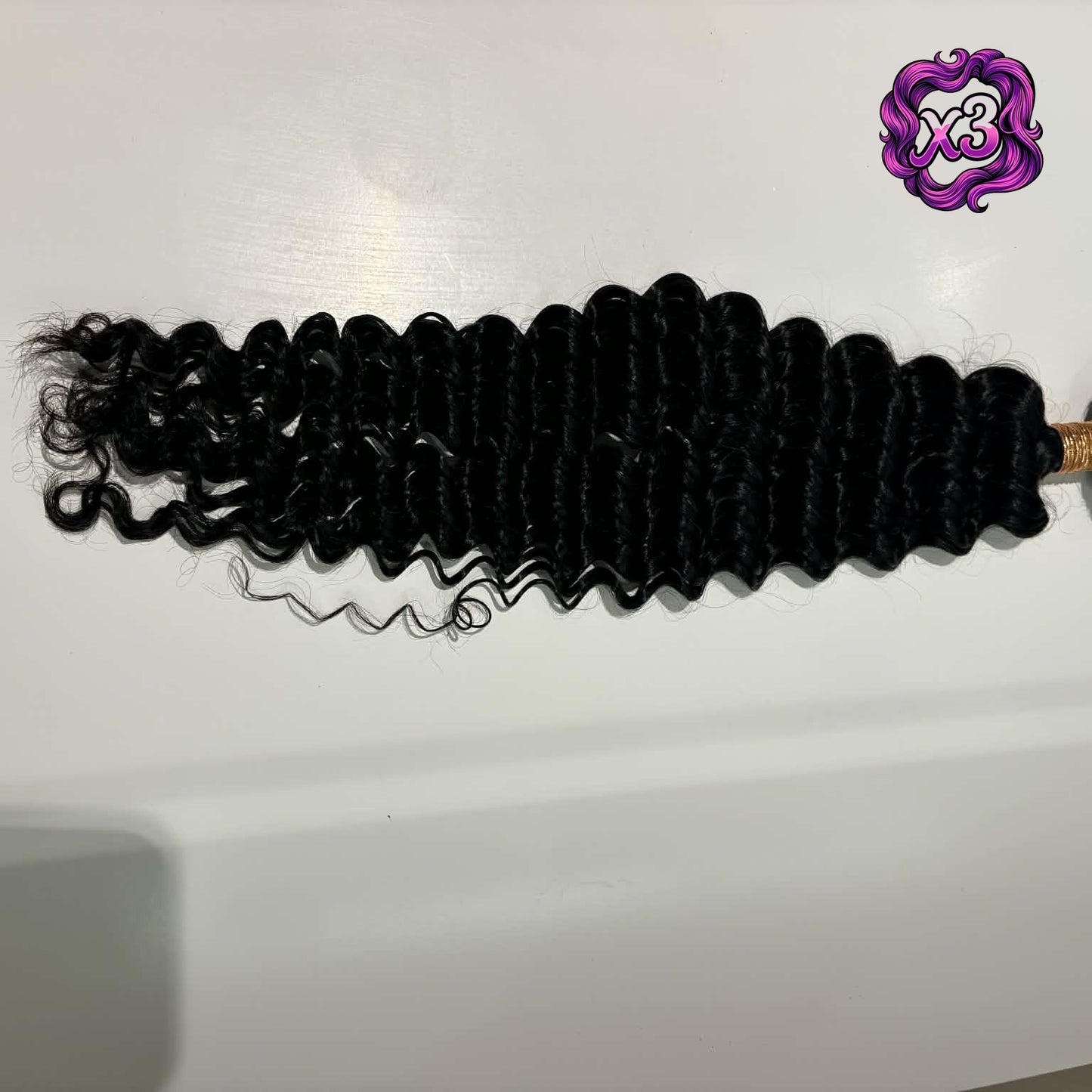 3 bundle deal — 16 inch Brazilian deep wave sew-in hair extensions bundle flat lay on shelf showing full bundle length with defined S-spiral waves