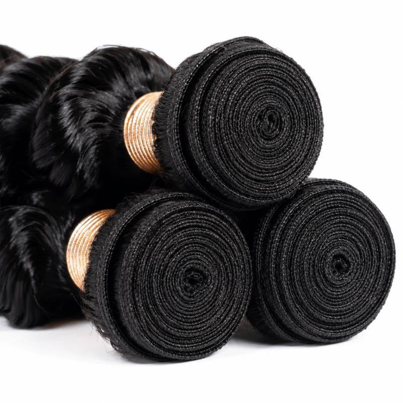 Close-up of the coiled weft ends on three bundles of natural black deep wave sew-in hair extensions with tan thread wraps