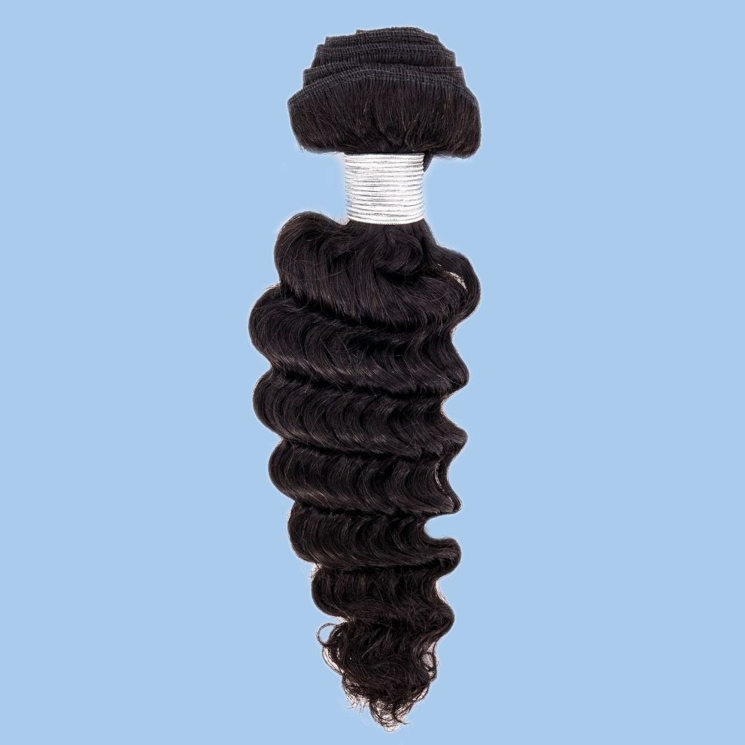 Single bundle of natural black deep wave sew-in hair extensions on a blue backdrop with white thread wrapping the weft