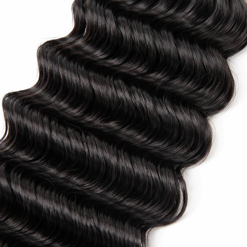 Close-up of the deep S wave pattern on natural black deep wave sew-in hair extensions against a white background
