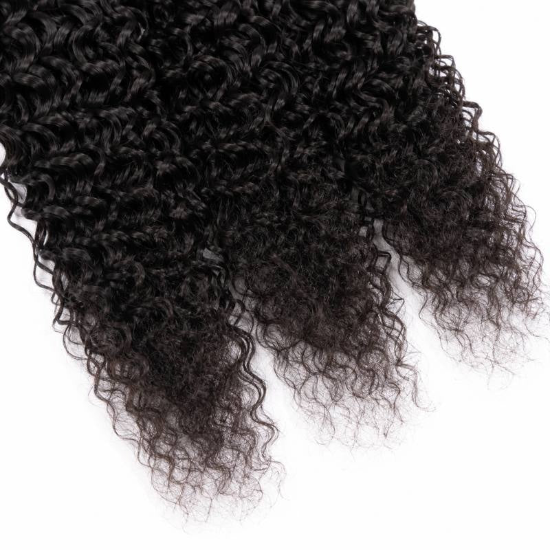 Close-up of the tapering tips of natural black kinky curly sew-in hair extensions showing tight coils against a white background
