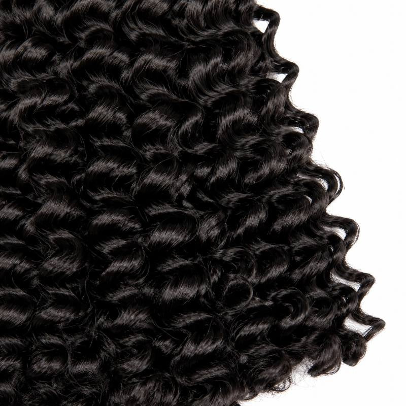 Macro close-up of the curl pattern along the edge of natural black kinky curly sew-in hair extensions against a white background