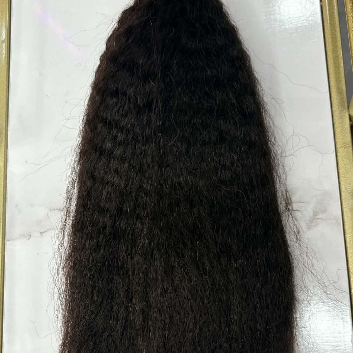 16 inch Brazilian kinky straight sew-in hair extensions bundle on marble in gold frame showing full length and natural blow-out texture