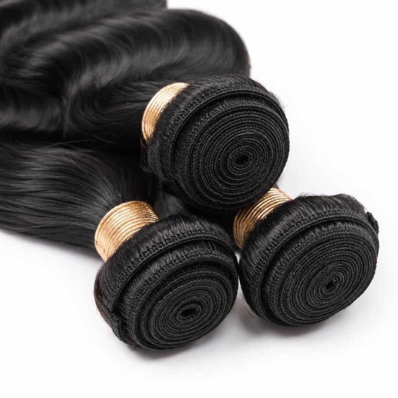 Close-up of three coiled weft tops on natural black loose wave sew-in hair extensions with gold thread wraps and spiral stitched tracks