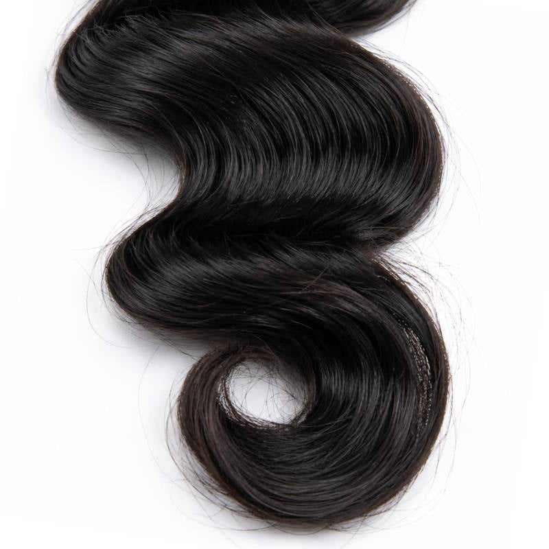 Close-up of the curled tip of natural black loose wave sew-in hair extensions where the wave rolls into a spiral on a white background