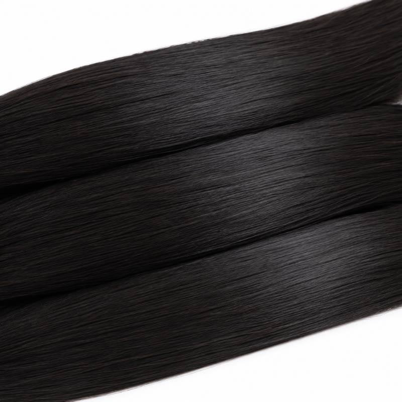 Macro view of three lengths of natural black straight sew-in hair extensions laid diagonally showing smooth shafts and surface shine