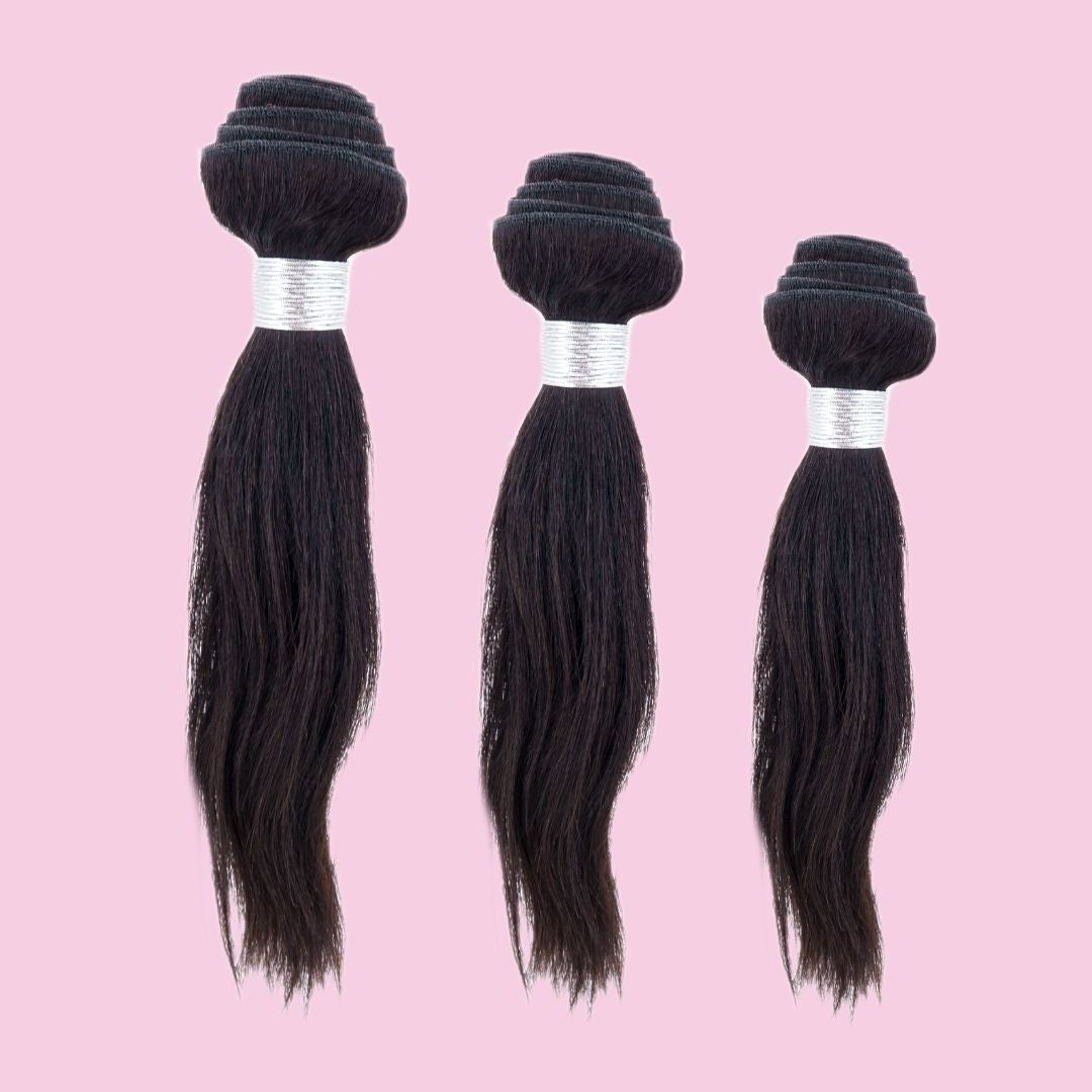 Three bundles of natural black straight sew-in hair extensions arranged in stepped heights on a pink backdrop with white weft wraps