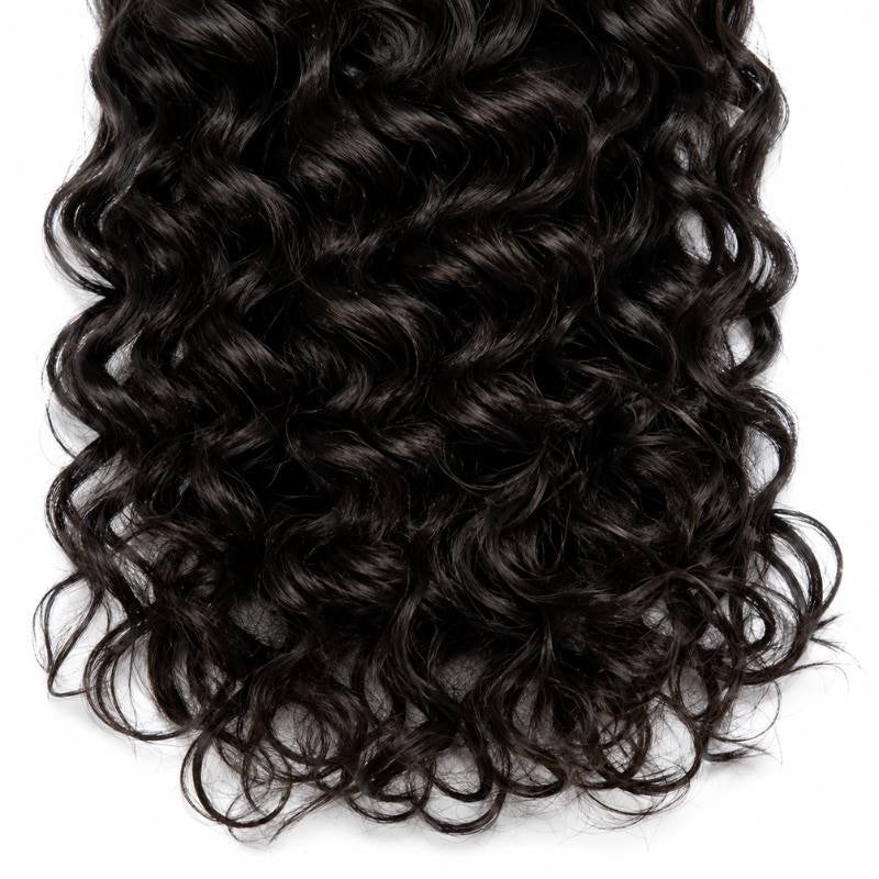 Close-up of the curling ends of natural black sew-in hair extensions showing tight ringlets against a white background