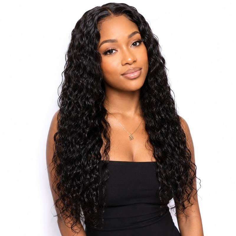 Model wearing natural black sew-in hair extensions in a defined wave pattern with a middle part falling past the shoulders