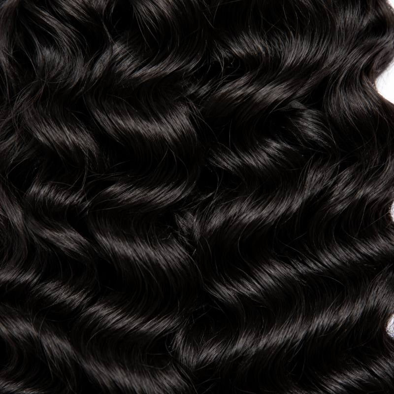 Macro view of natural black sew-in hair extensions filling the frame with a repeating S shaped wave pattern