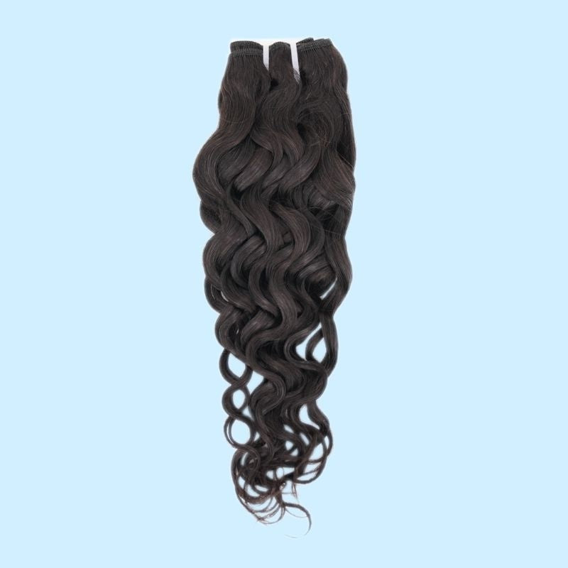 Natural black sew-in hair extensions weft photographed against a pale blue backdrop showing spiral waves through the mid lengths and ends