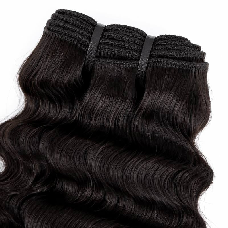 Close-up of the stitched weft tracks on natural black sew-in hair extensions held with tape tabs above softly waved hair