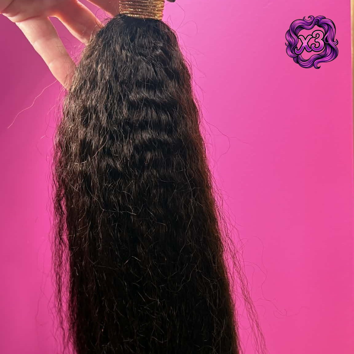 3 bundle deal — Hand holding 16 inch Brazilian kinky straight sew-in hair extensions bundle against pink wall showing full length and natural volume