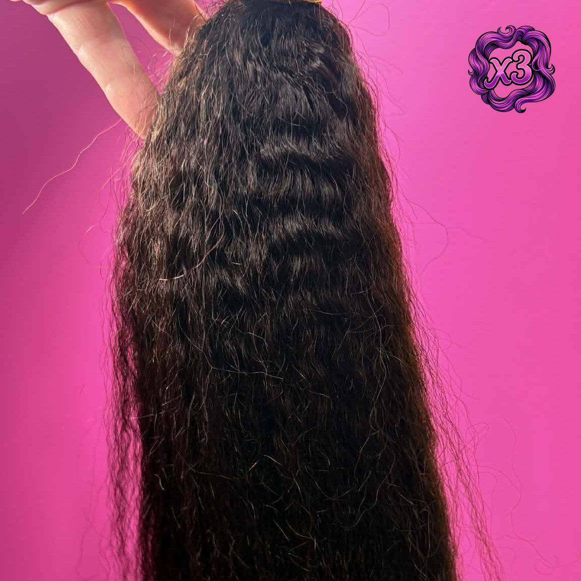 3 bundle deal — Hand holding 16 inch Brazilian kinky straight sew-in hair extensions bundle against pink wall showing weft and fluffy straight texture