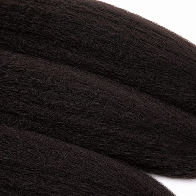 Macro view of natural black kinky straight sew-in hair extensions laid diagonally showing the crimped surface of the strands