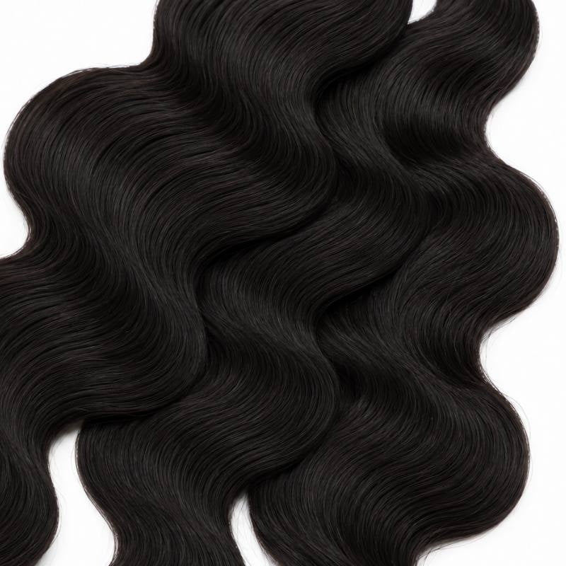 Macro view of natural black body wave sew-in hair extensions showing the flowing S wave pattern across the frame