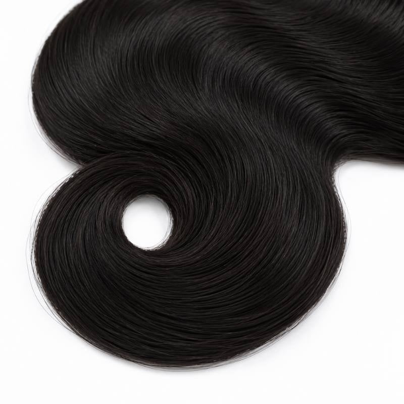 Close-up of the end of natural black body wave sew-in hair extensions curling into a rounded ring on a white background