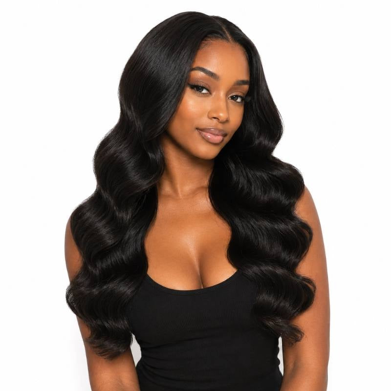 Model on a white background wearing natural black body wave sew-in hair extensions with a middle part and deep S waves through the lengths