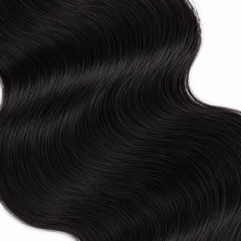Macro view of natural black body wave sew-in hair extensions showing a broad S curve through the mid lengths on a white background