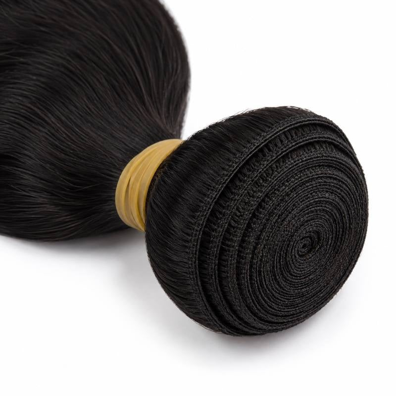 Macro close-up of the spiral coiled weft on natural black body wave sew-in hair extensions held by a yellow elastic band