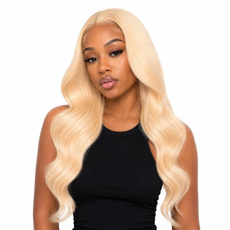 Model on a white background wearing blonde body wave sew-in hair extensions with a middle part and loose waves through the lengths