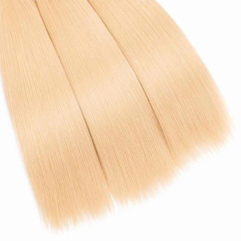 Close-up of the blunt ends of three bundles of blonde straight sew-in hair extensions on a white background