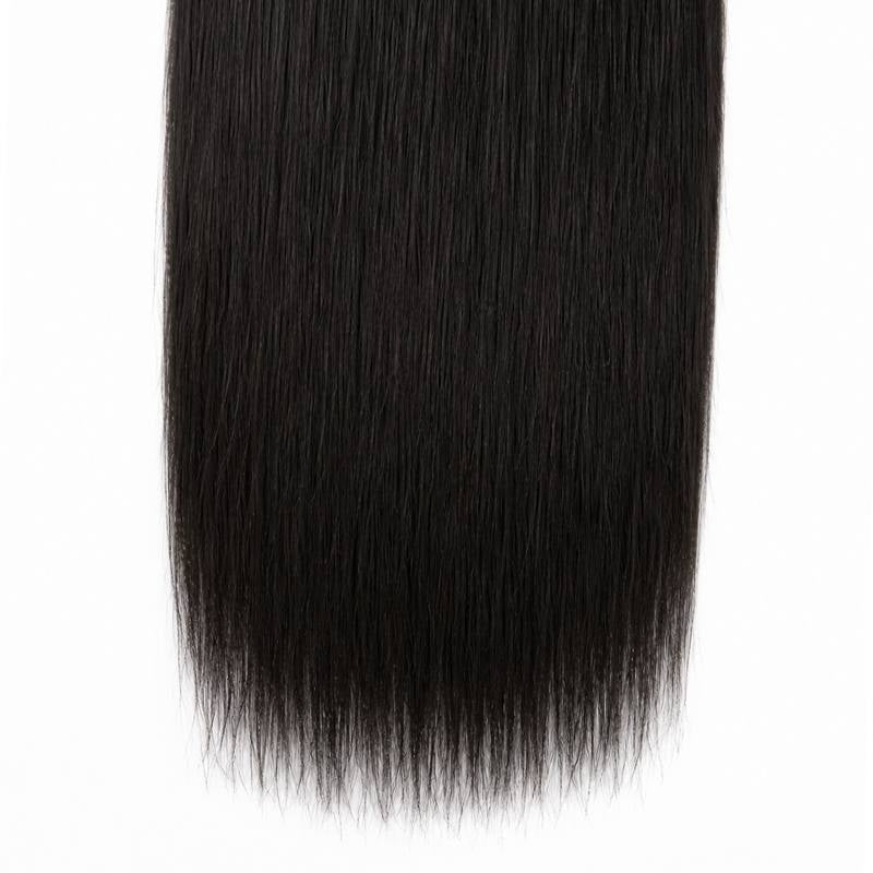 Close-up of the blunt cut ends of natural black yaki straight sew-in hair extensions against a white backdrop