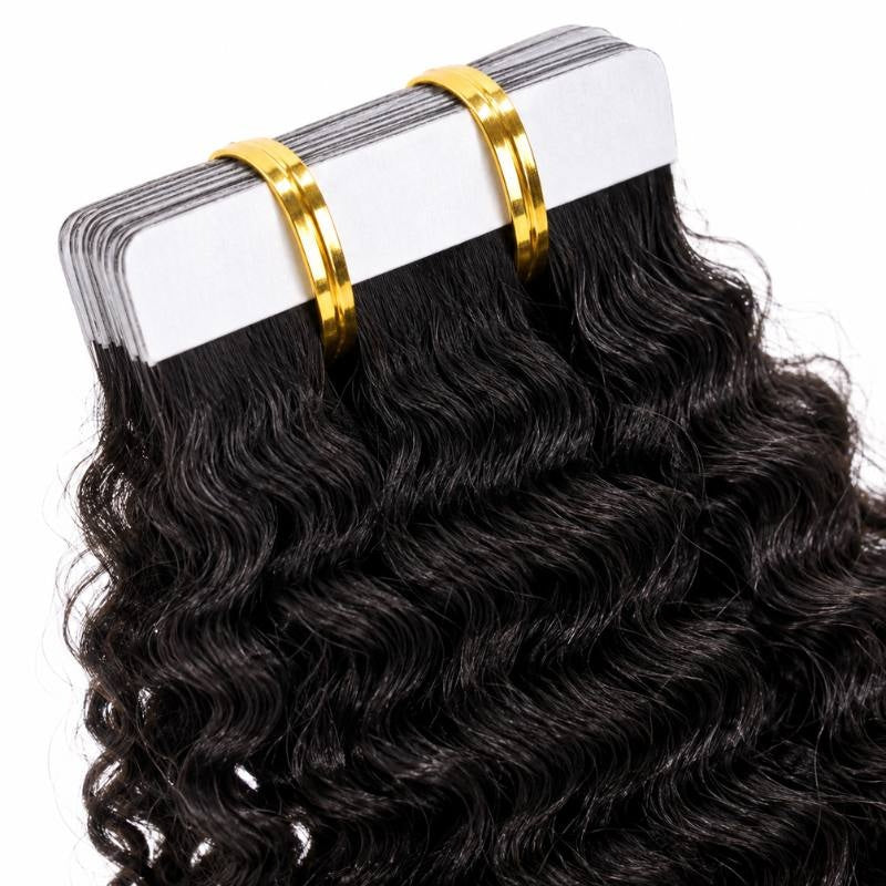 Angled close-up of the white adhesive tape tabs on natural black afro kinky curly tape-in hair extensions held in a banded stack